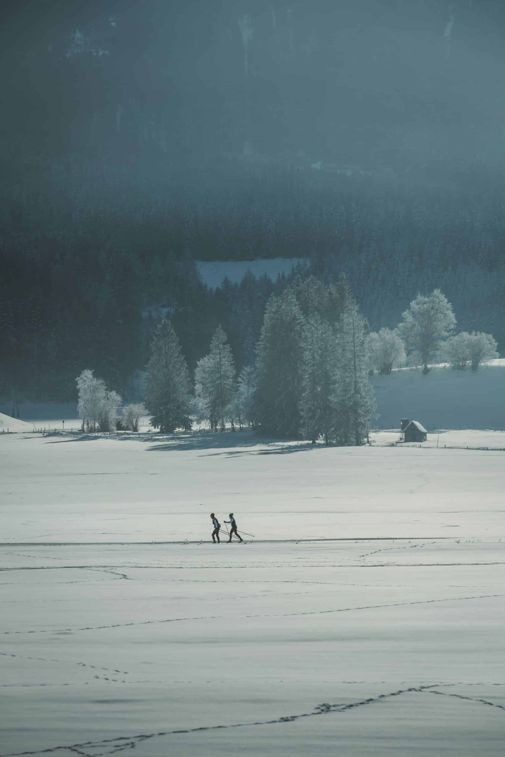 A group of people walking across a snow covered field